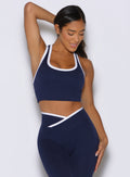 front view of a model holding her hair with one hand wearing the Finish Line Tank in navy color