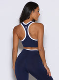 back profile view of a model facing to the right side wearing the Finish Line Tank in navy color