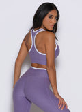 back profile view of a model looking over her shoulder wearing the Finish Line Tank in Violet color