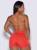 back profile view of a model facing to the right side wearing the FitBoost Bra in Command Red color