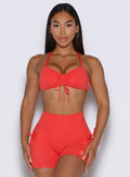 front profile view of a model showcasing the tied ersion of the front strap on the FitBoost Bra in Command Red color