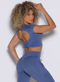 back right side profile view of a model looking over her shoulder wearing the FitBoost Tee in Blue slate color