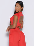 left side profile view of a model looking over her shoulder wearing the FitBoost Tee in Command red color