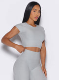 front right side profile view of a model wearing our Fit Fam Active Tee in cloud color along with the matching Leggings