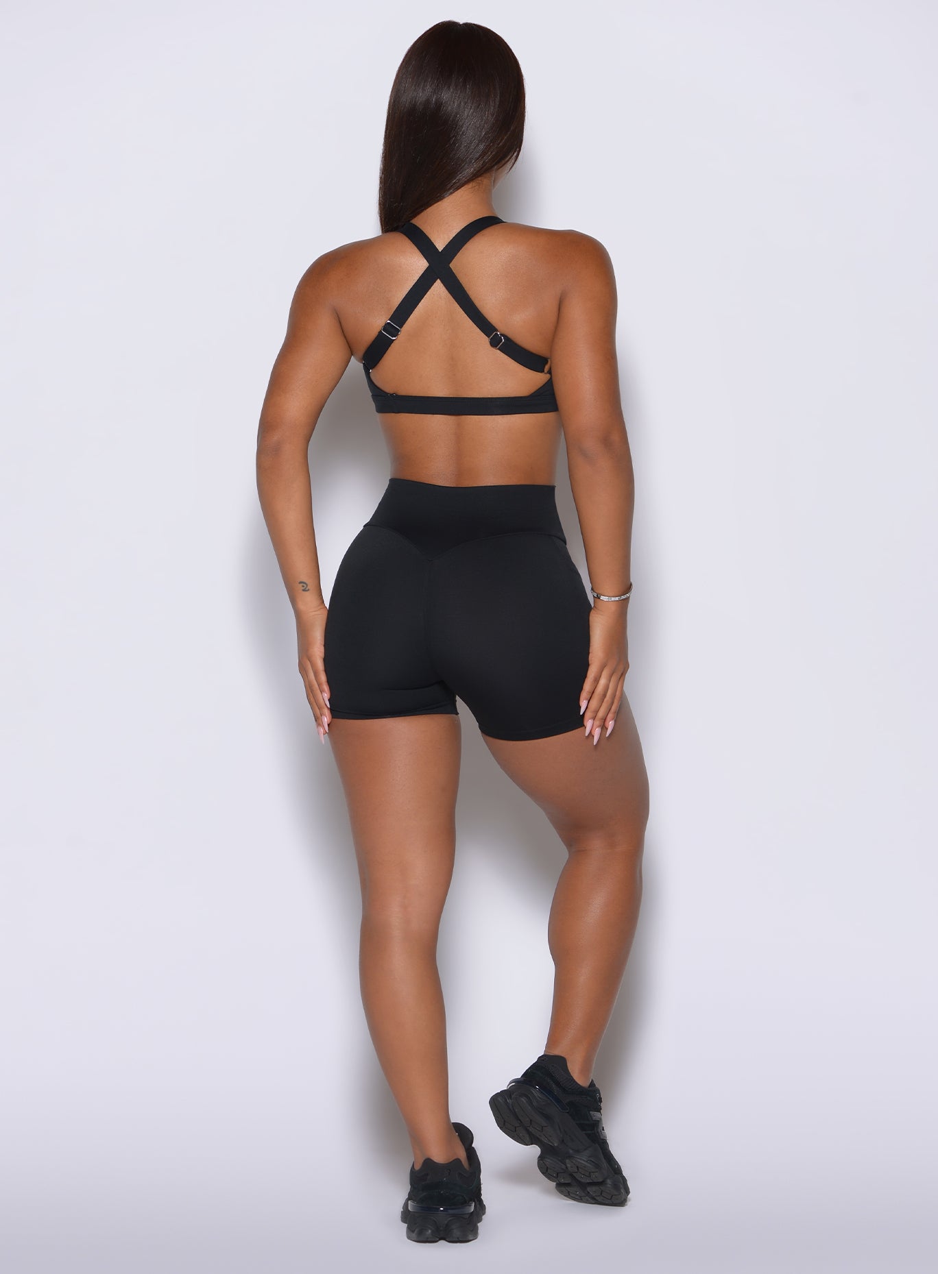 Rear angle shows a 3¾” inseam and a secure, non-sagging fit across the glutes in solid black