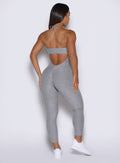 back profile view of a model wearing the flawless form bodysuit in dark and stormy color