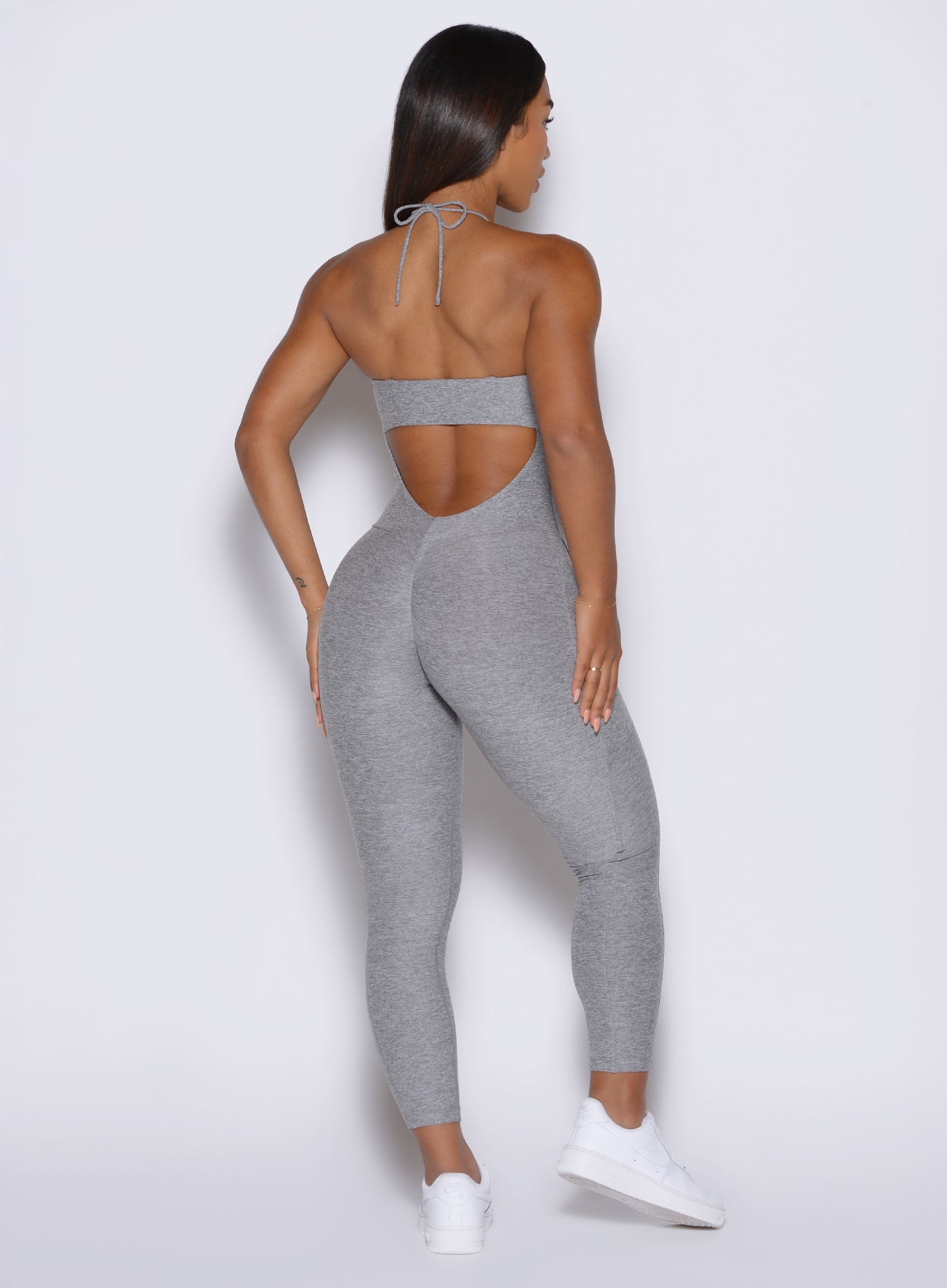 back profile view of a model wearing the flawless form bodysuit in dark and stormy color