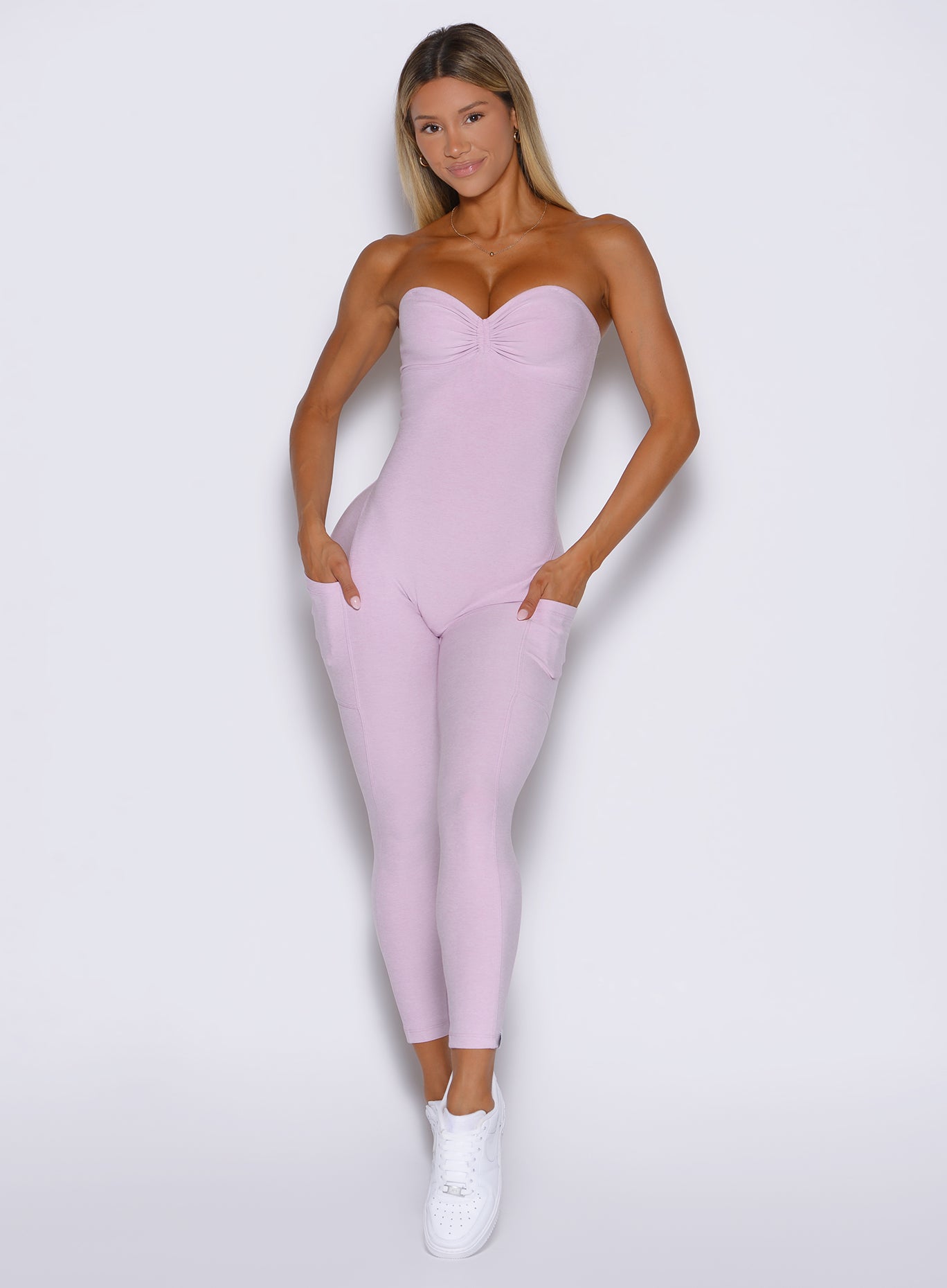 front profile view of a model wearing the flawless form bodysuit in pink paloma color