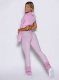 left side profile view of a model wearing the flawless form bodysuit in pink paloma color