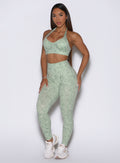 Front profile view of the model dressed in our Flexfit leggings in Leopard Cool Matcha paired with the matching top