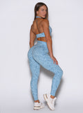 Back right side profile view of the model posing wearing our Flexfit leggings in Leopard Glacial Blue.