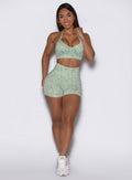 Front profile view of the model wearing our Flexfit shorts in Leopard Cool Matcha with a matching bra.