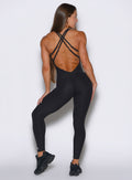back profile view of a model facing to the right side wearing the Form Bodysuit in Heathered Black color