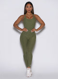 front profile view of a model with both hands on her waist wearing the Form Bodysuit in Lily Pad color