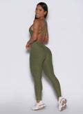 back left side profile view of a model looking over her shoulder wearing the Form Bodysuit in Lily Pad color