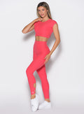 front left side profile view of a model wearing the Form Flex Leggings in watermelon punch color