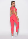 back right side profile view of a model wearing the Form Flex Leggings in watermelon punch color paired with the matching tee