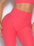 close up front profile view of a model wearing the Form Flex Leggings in watermelon punch color