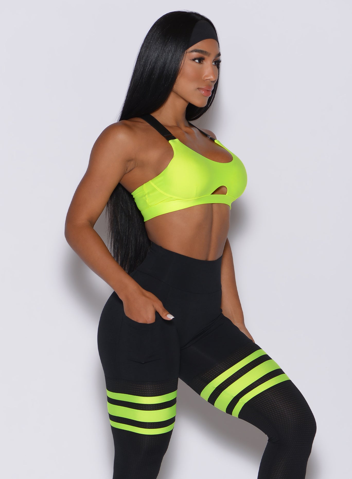 Right side profile view of a model in our glow sports bra in neon yellow and a matching leggings