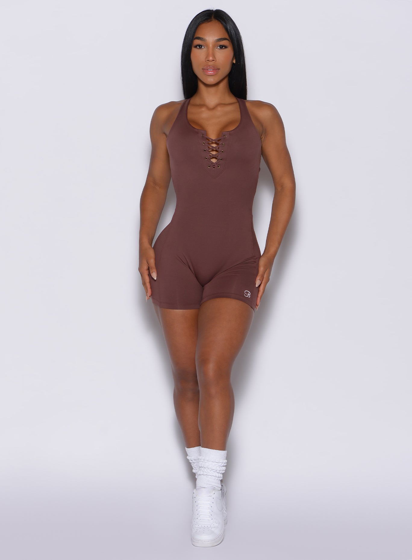 front profile view of a beautiful model in our laced bodysuit shorts in chocolate color 