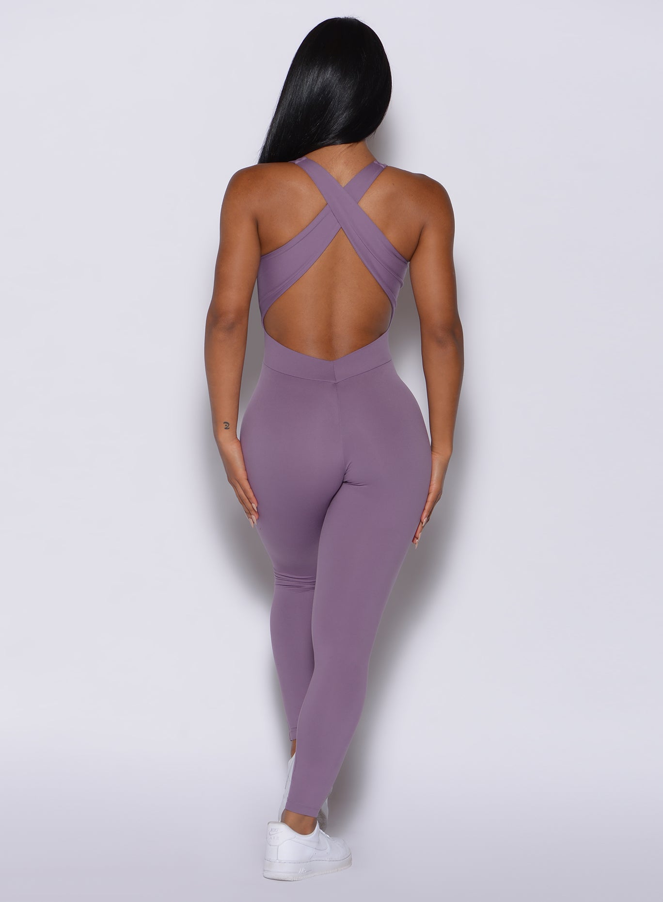 back  profile view of a model wearing our laced bodysuit in Violet Frost color