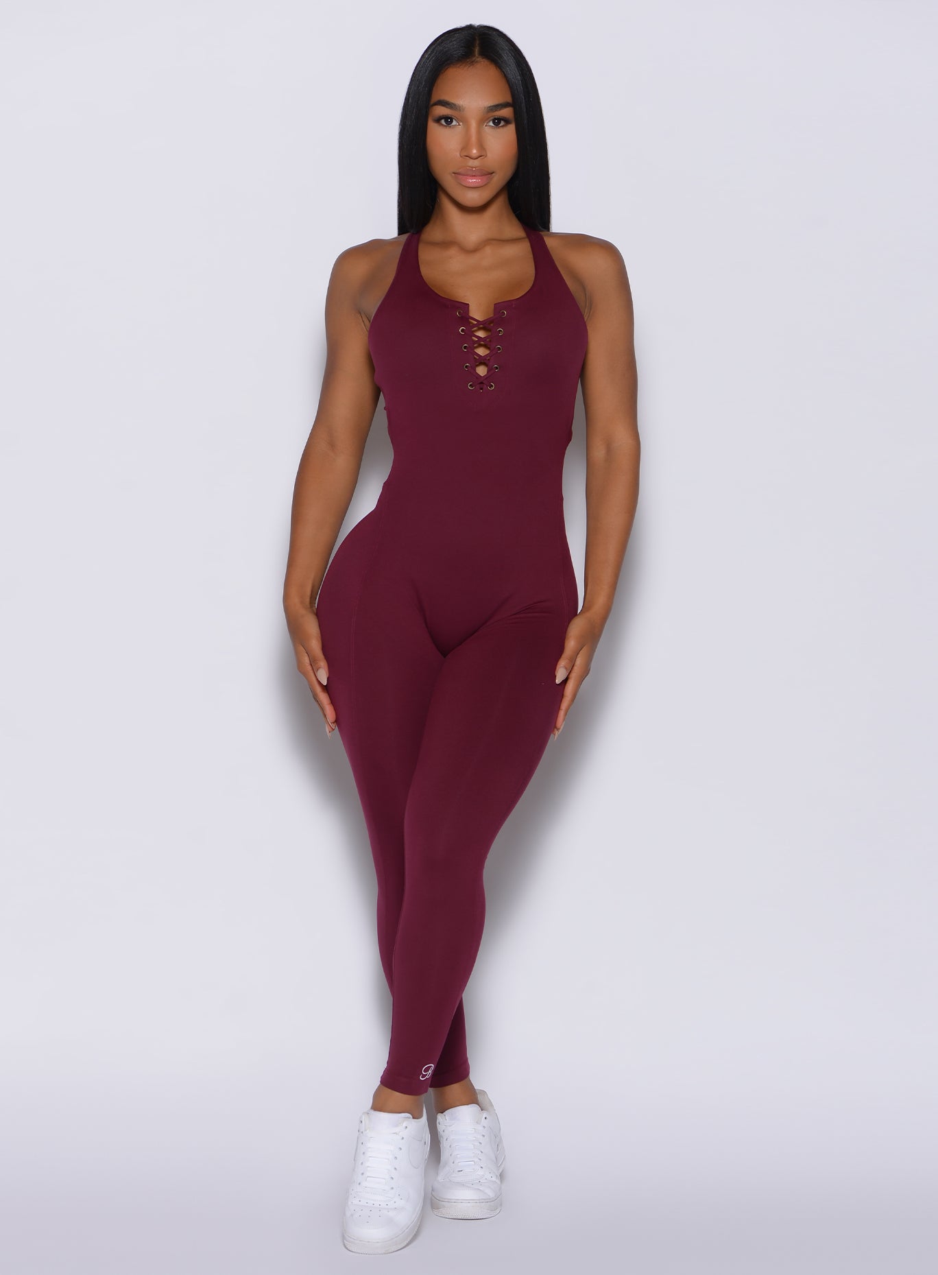 model facing forward wearing our laced bodysuit in ruby color 