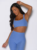 front profile view of a model facing down wearing the Halo Sports Bra in boss blue color