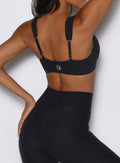 close up detailed shot of a model from the back wearing the Halo Sports Bra in Heathered Black color