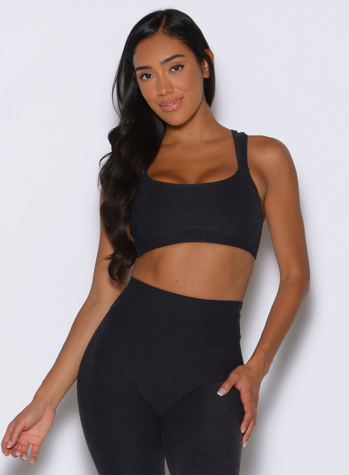 front profile view of a model wearing the Halo Sports Bra in Heathered Black color