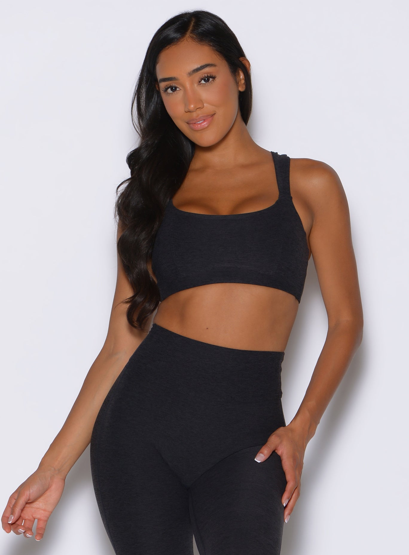 front profile view of a model wearing the Halo Sports Bra in Heathered Black color