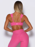 back profile view of a model wearing the Halo Sports Bra in pink glo color