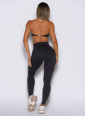 back profile view of a model wearing the Hardbody Leggings in Heathered Black color