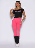 front view of a model looking to the right side wearing the Hardbody Leggings in Neon Flame color
