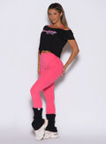 front left side view of a model wearing the Hardbody Leggings in Neon Flame color