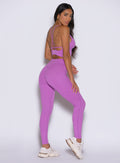 back right side profile view of a model looking over her shoulder wearing the Hardbody Leggings in Purple Rain color