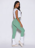 White Luxe Leg Warmers in a short length paired with sage green sculpting gym leggings.
