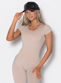 front profile view of a model wearing a peach bodysuit and our black faux leather hat