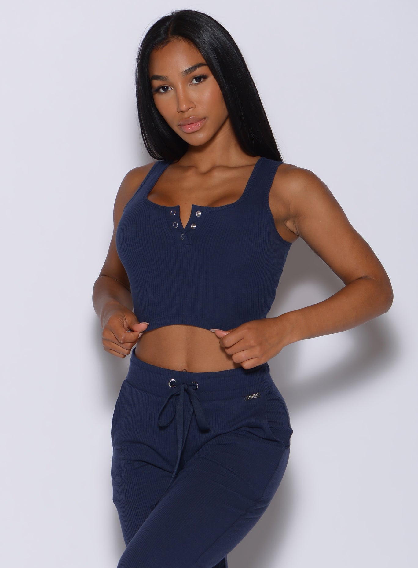 Front profile view of a model wearing our henley long bra in navy and a matching joggers
