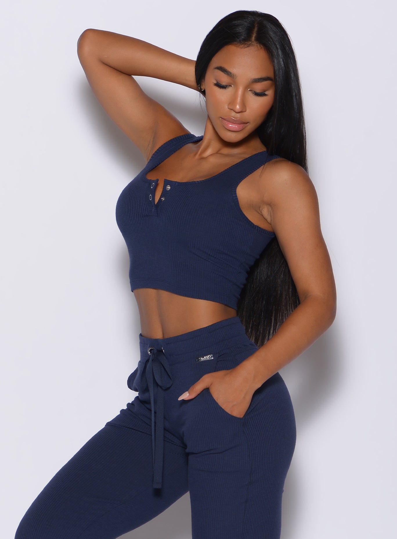 left side profile view of a model wearing our henley long bra in navy and a matching high waisted  joggers