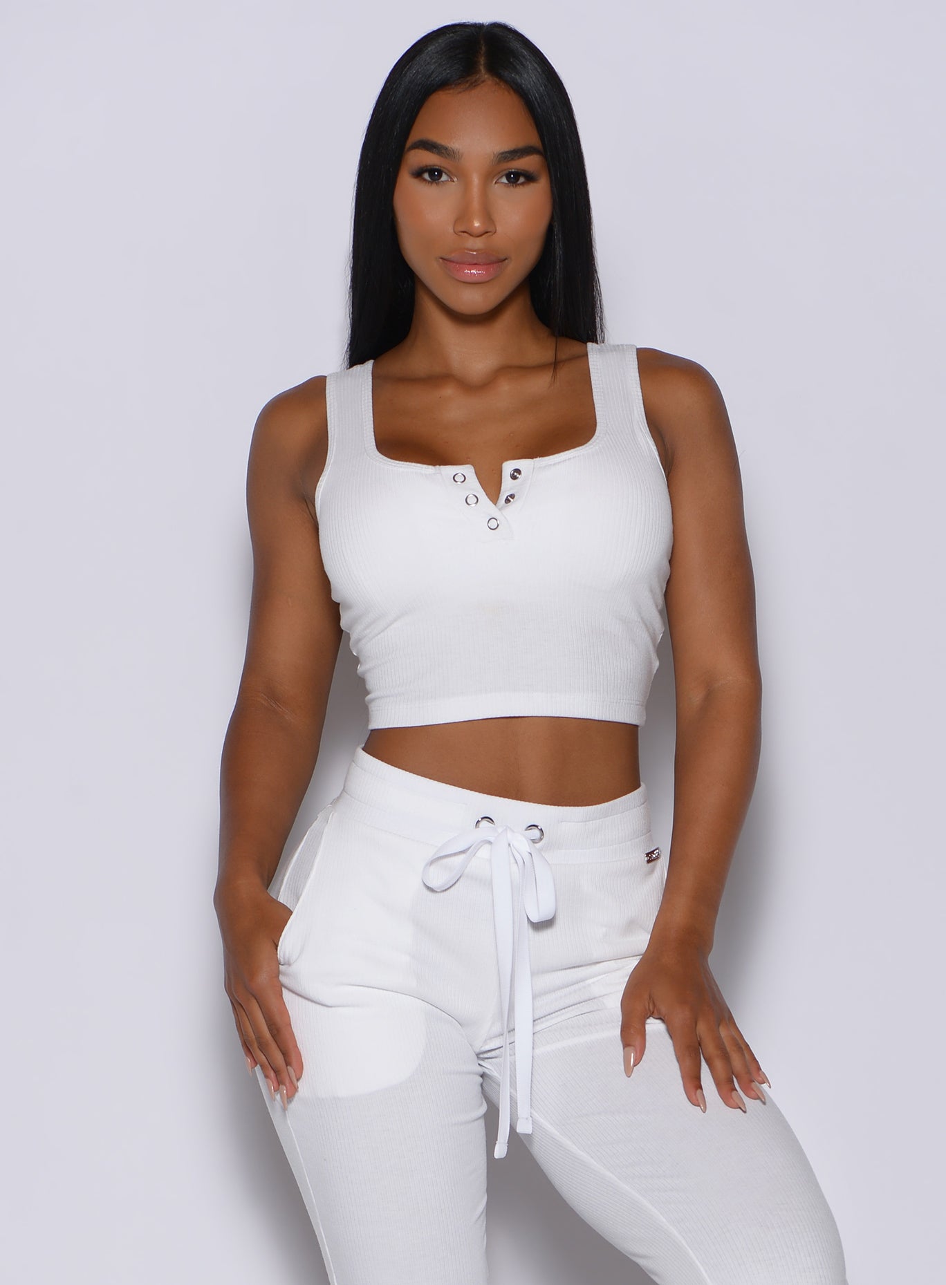Front profile view of a model wearing our white henley long bra and a matching joggers 