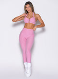 front profile view of a model wearing the Movement Leggings in Candy Pink color paired with the matching bra
