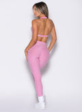 back profile view of a model facing left wearing the Movement Leggings in Candy Pink color