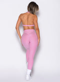 back profile view of a model wearing the Movement Leggings in Candy Pink color