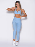 front profile view of a model with one hand on the waist wearing the Movement Leggings in Blue Mist color