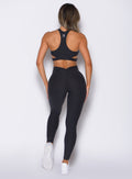 back profile view of a model with both hands on her thighs wearing the V Butt Lift Leggings in Heathered Black color