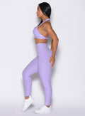 left side profile view of a model wearing the Movement Leggings in Sugared Lilac color