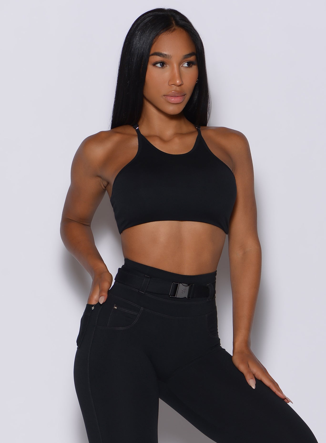 Front profile view of a model wearing our black high neck crop bra and a matching leggings 