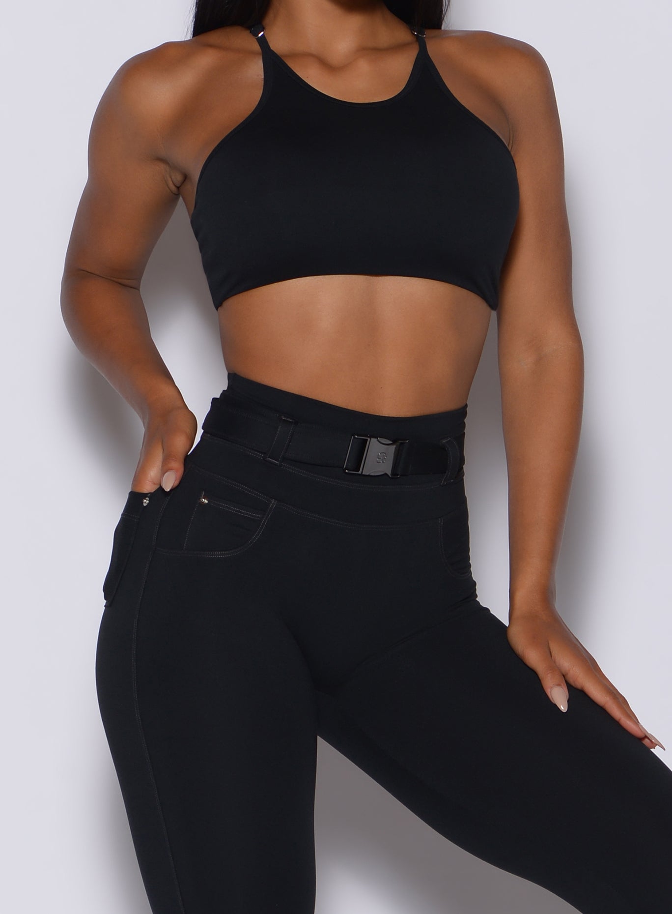 close up front profile view of a model in our black high neck crop bra and a matching leggings