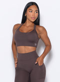 front profile view of a model wearing our High Impact Bra in Seal Brown color and the matching leggings
