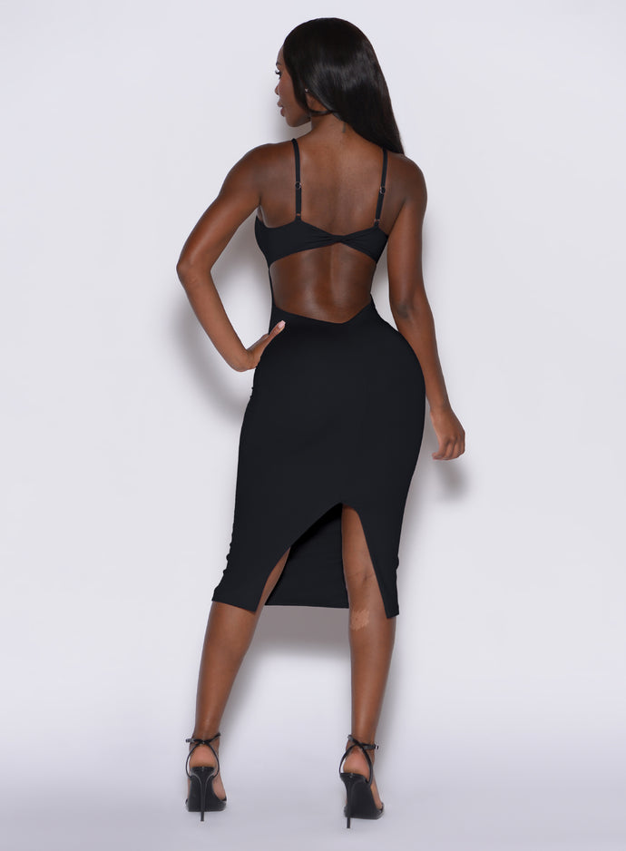 Back profile picture of a model standing and wearing our black hourglass dress 